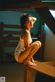 A woman sitting on top of a wooden bench.