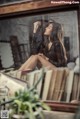 A woman sitting on top of a pile of books.