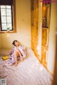 A woman sitting on a bed in a room.