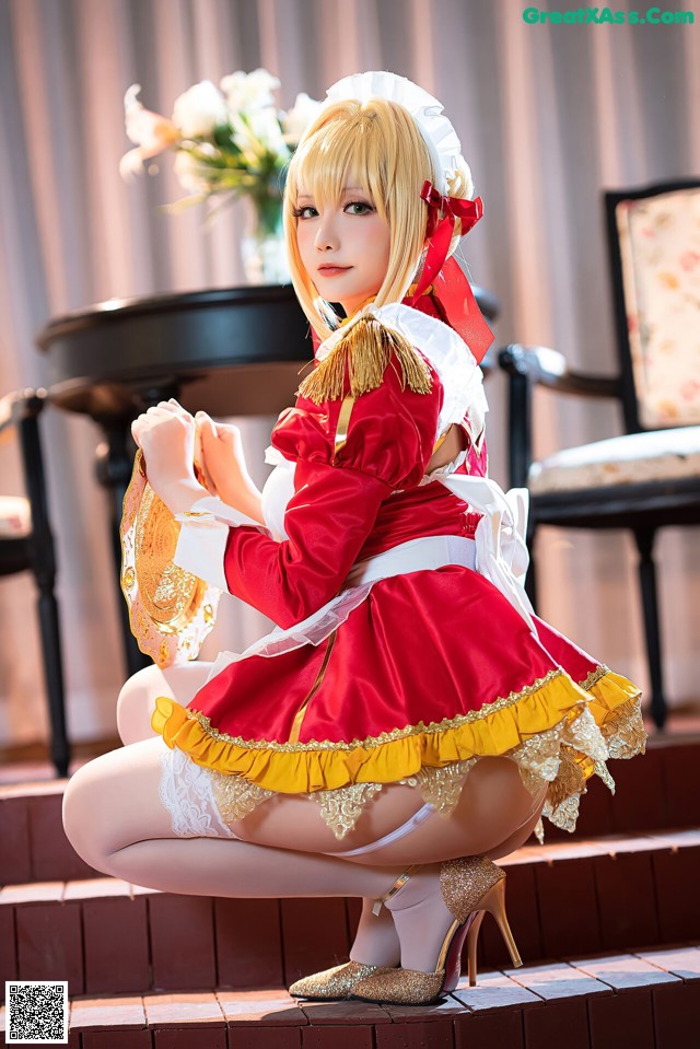 A woman in a red and yellow dress sitting on a set of stairs.