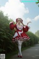 A woman in a red and white dress is walking down a road.