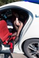 A woman sitting in the back seat of a white car.
