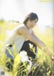 A woman sitting in a field of tall grass.