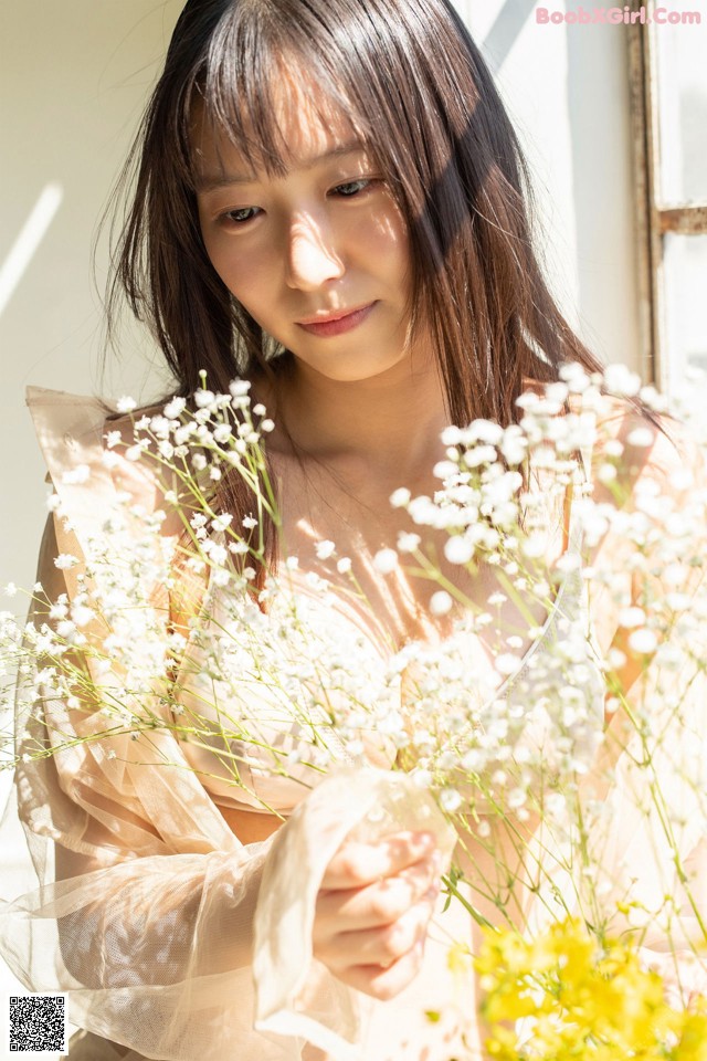 A woman holding a bunch of flowers in her hands.